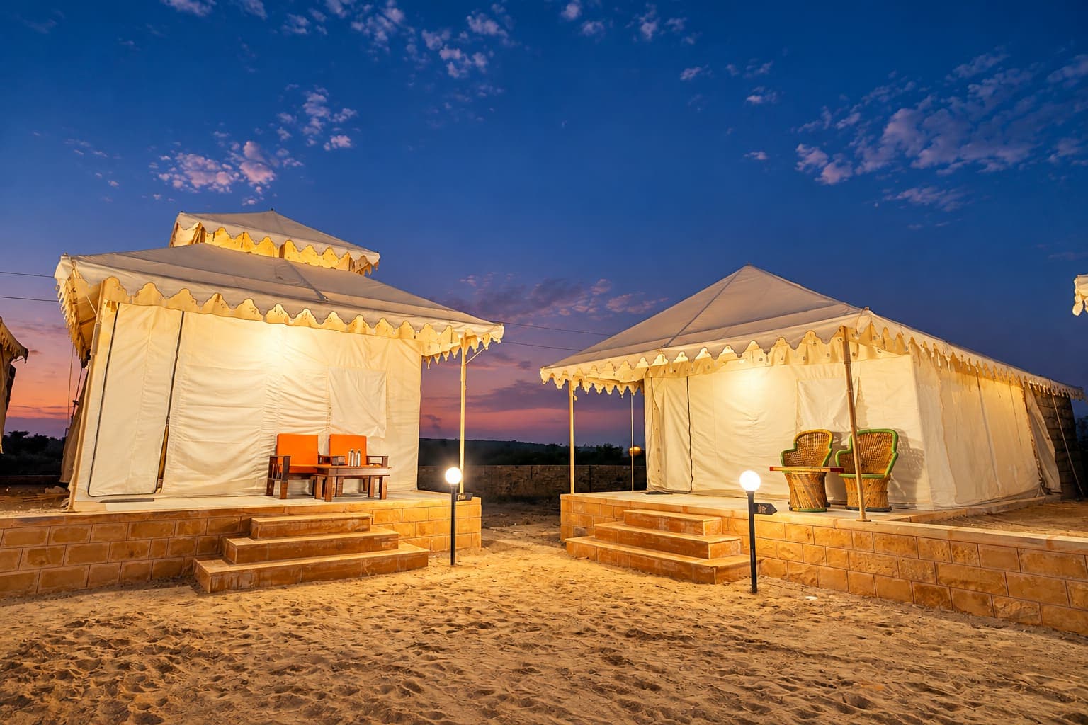 Two Deluxe Swiss tents with sandstone steps under a twilight desert sky