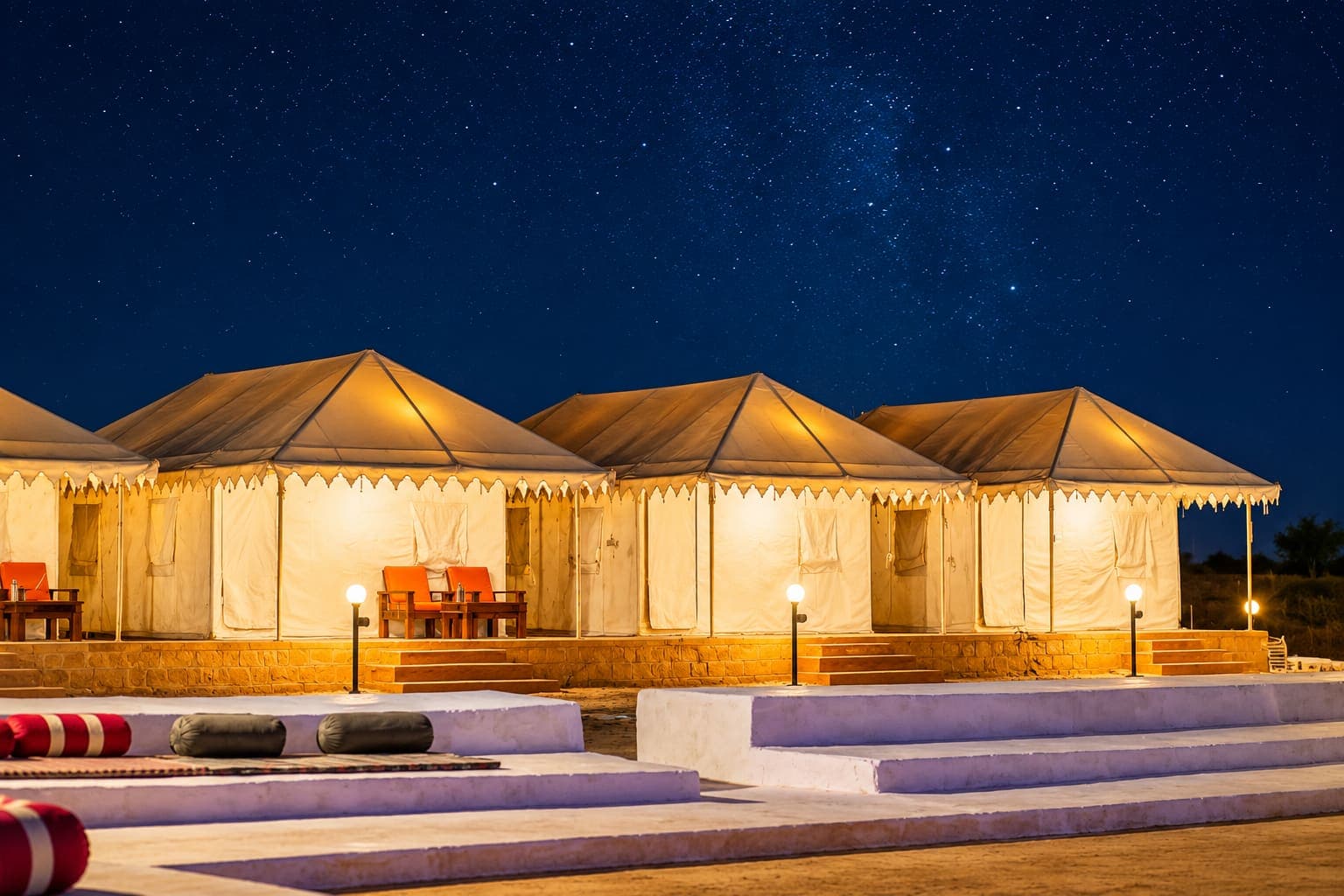 Open-air cultural programme seating with tents lit up behind at night