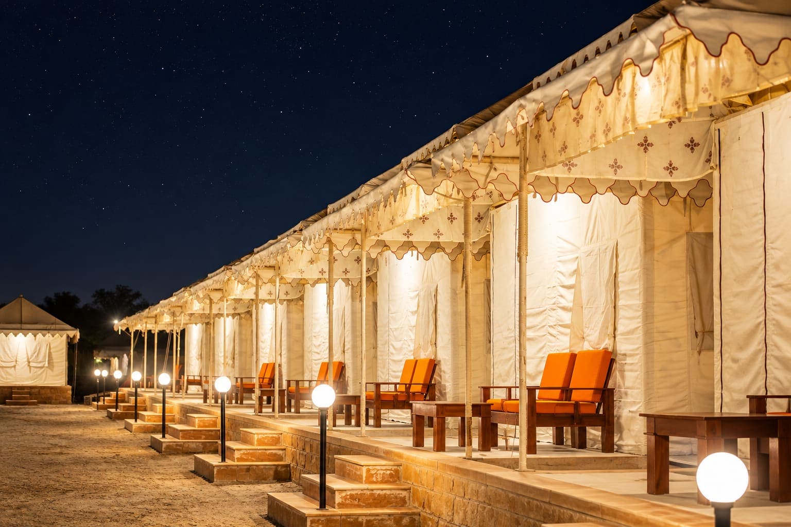 Row of illuminated Royal Maharaja Swiss tents with private verandas at Desert Overnight Camp, Sam Sand Dunes Jaisalmer