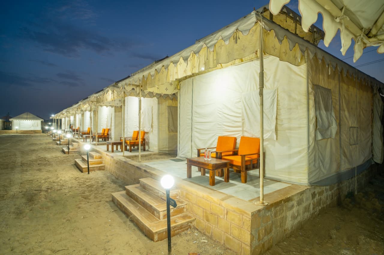 Luxury Swiss tent verandas with orange lounge seating at twilight